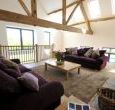 living room with big squashy sofas, plasma tv and woodburner